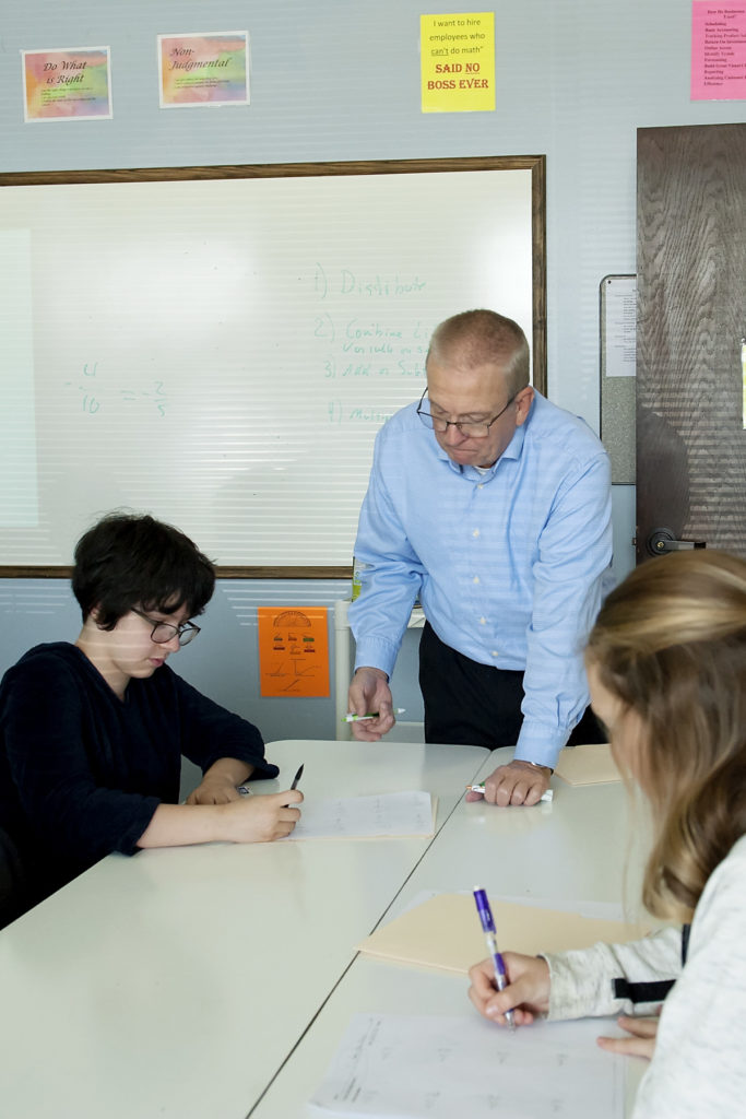 Aged teacher examine students work